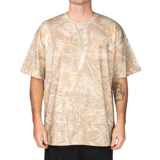 Person wearing a beige camouflage t-shirt on a gray background