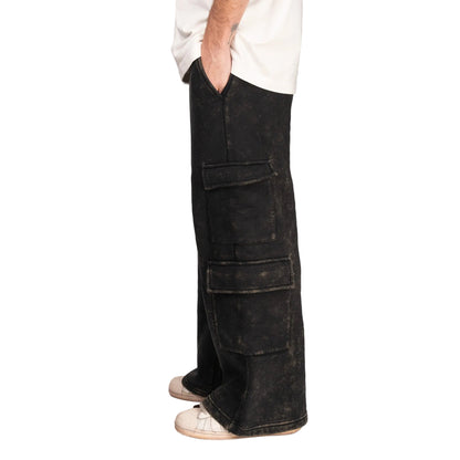 Person wearing black cargo pants on a gray background