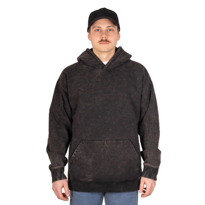 Person wearing a black hoodie and cap on a gray background