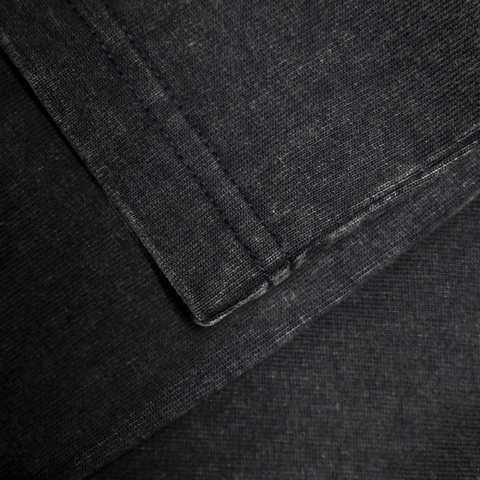 Close-up of dark gray fabric with a focus on texture and stitching.