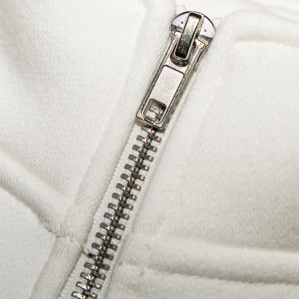 Close-up of a silver zipper on a white jacket